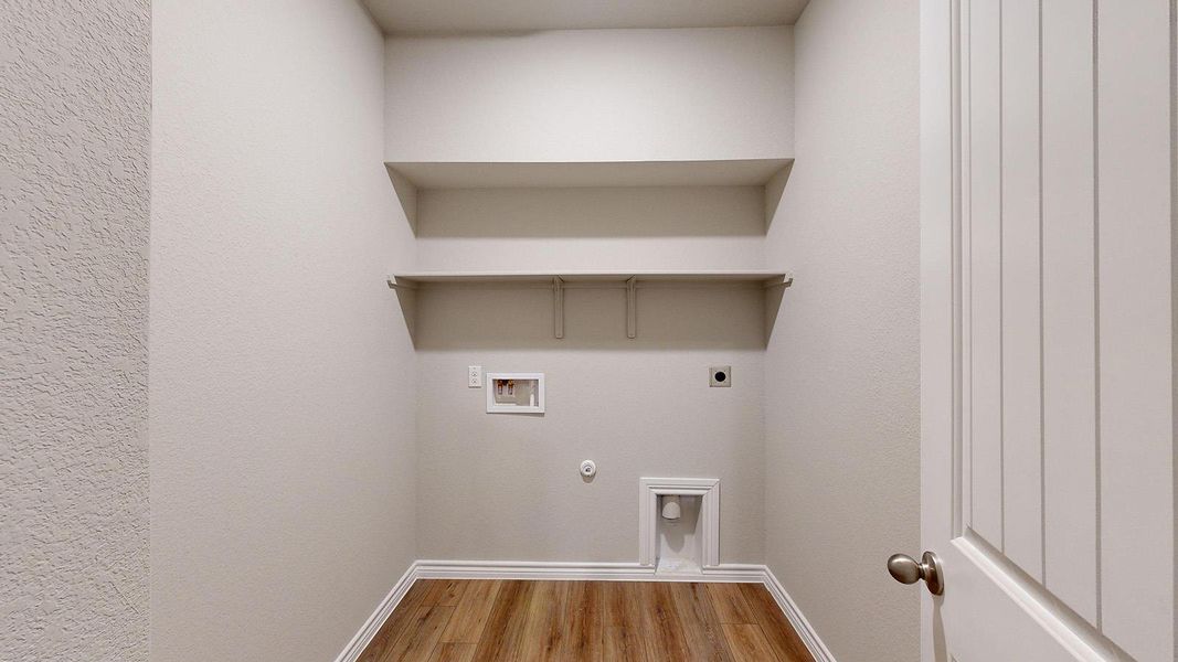 Laundry room featuring hookup for a gas dryer, light wood-style floors, hookup for a washing machine, hookup for an electric dryer, and a textured wall