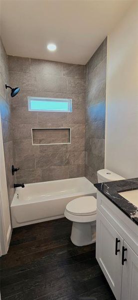 Bathroom featuring vanity, washtub / shower combination, and dark wood finished floors Bathroom featuring vanity, washtub / shower combination, and dark wood finished floors