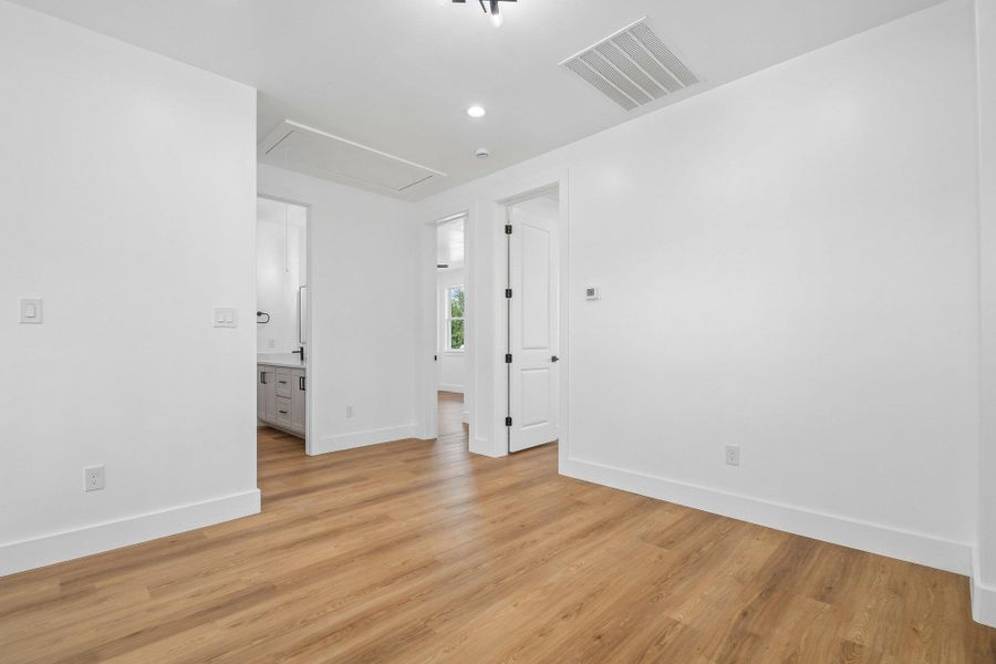 Warm wood flooring contrasts with crisp white walls in this versatile secondary bedroom space. Warm wood flooring contrasts with crisp white walls in this versatile secondary bedroom space.