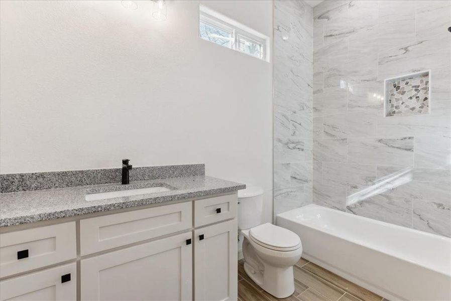 Full bathroom featuring vanity, toilet, and tiled shower / bath