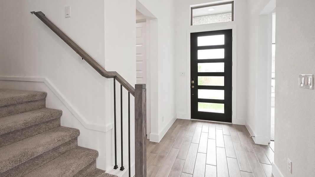 Entrance foyer with stairway, light wood-style flooring, baseboards, and a healthy amount of sunlight