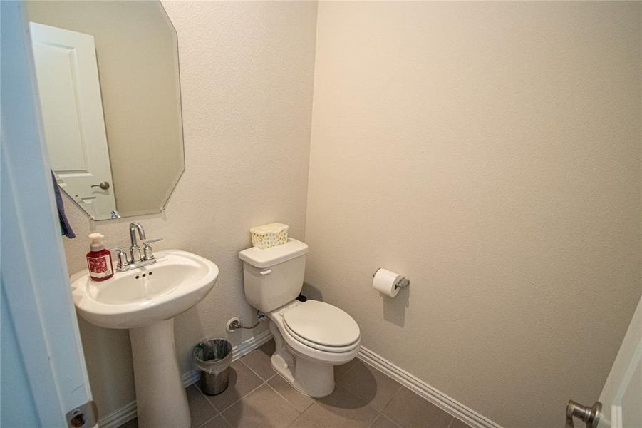 Half bath with a textured wall and tile patterned flooring Half bath with a textured wall and tile patterned flooring