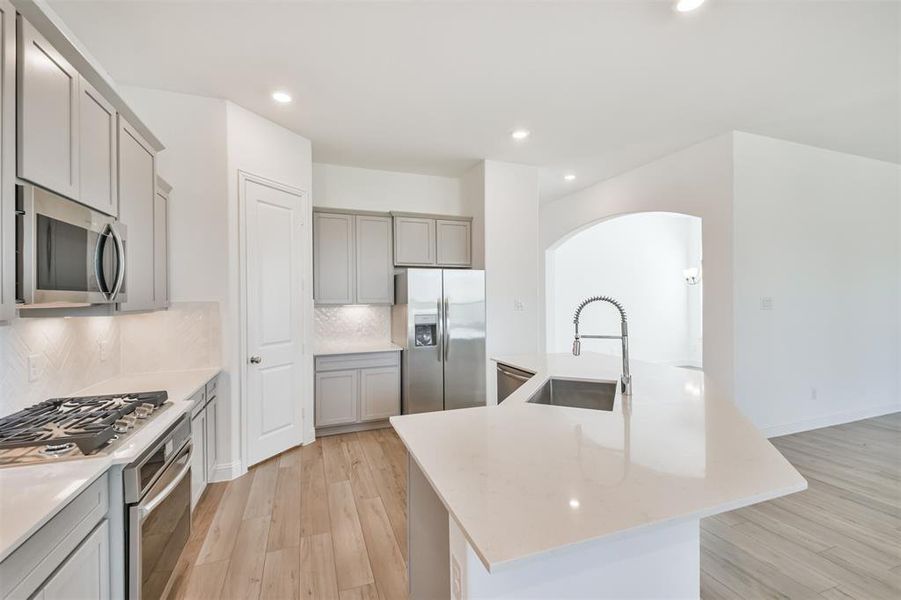 Another View Of The Kitchen Highlights it's Abundant Cabinet Space, Ample Storage, and a Convenient walk-in Pantry