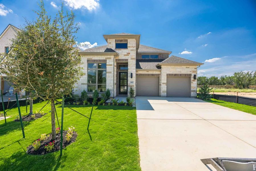 View of front facade with stone siding, concrete driveway, a garage, and a shingled roof View of front facade with stone siding, concrete driveway, a garage, and a shingled roof
