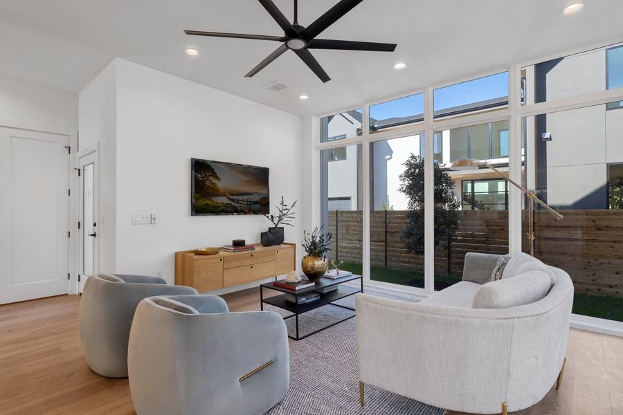 Living area with recessed lighting, floor to ceiling windows, light wood finished floors, and ceiling fan Living area with recessed lighting, floor to ceiling windows, light wood finished floors, and ceiling fan