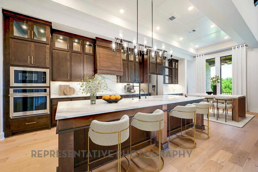 Kitchen featuring dark brown cabinets, glass insert cabinets, light wood-style floors, appliances with stainless steel finishes, and recessed lighting Kitchen featuring dark brown cabinets, glass insert cabinets, light wood-style floors, appliances with stainless steel finishes, and recessed lighting