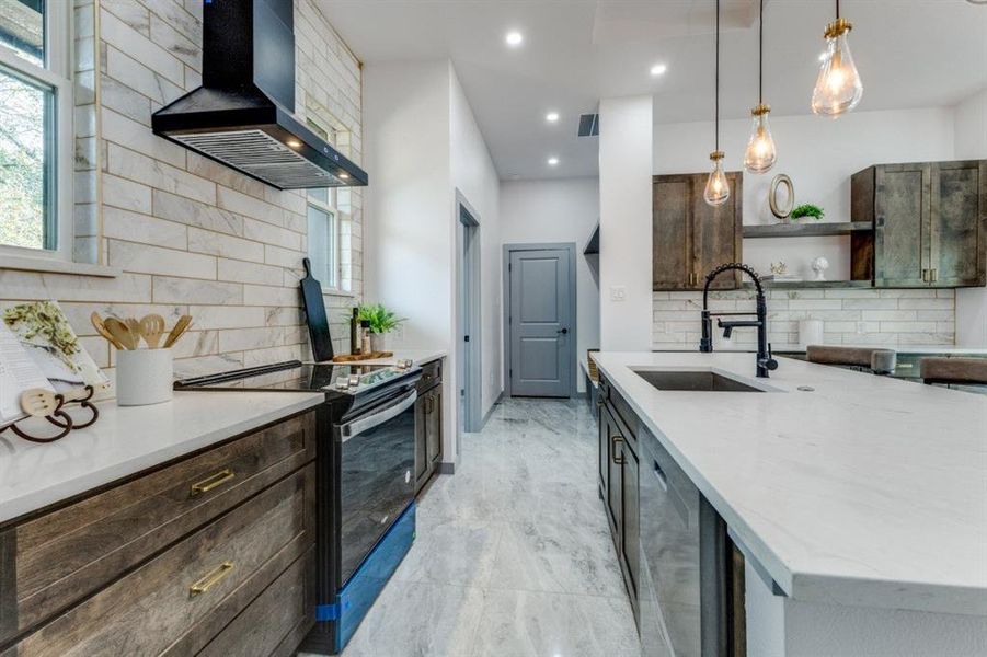 Kitchen featuring sink, dark brown cabinets, hanging light fixtures, ventilation hood, and electric range