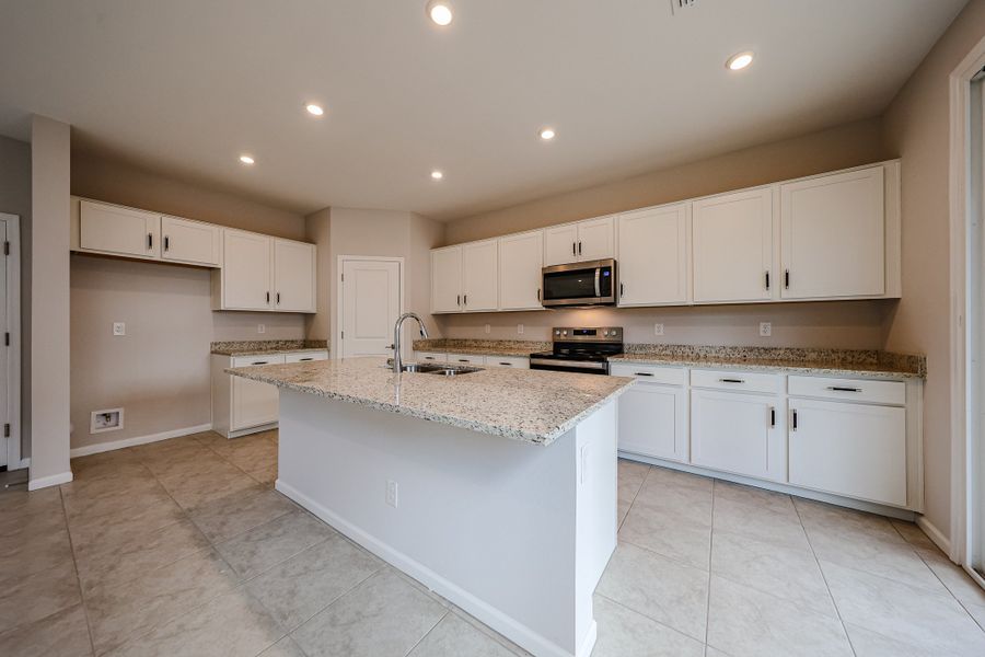 A kitchen with white cabinets.