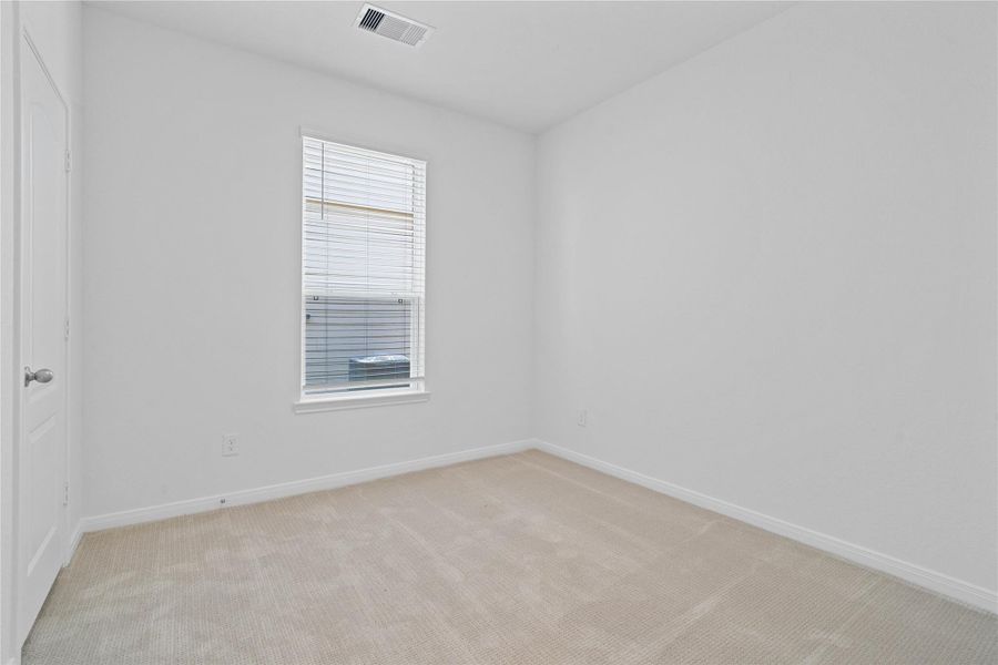 This secondary bedroom offers comfort and style with plush carpet flooring, neutral paint tones, a large window with blinds, and ample sized closet space. This secondary bedroom offers comfort and style with plush carpet flooring, neutral paint tones, a large window with blinds, and ample sized closet space.