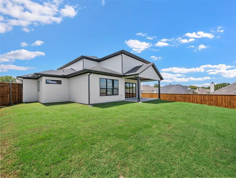 Rear view of house with a patio area and a yard