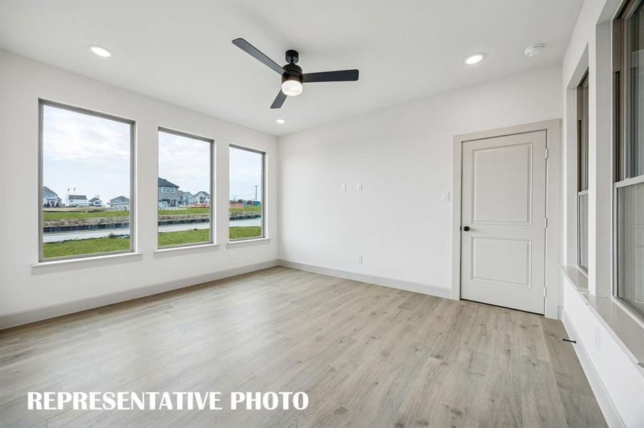 A wall of windows floods this family room with natural light creating a bright and inviting space.  REPRESENTATIVE PHOTO