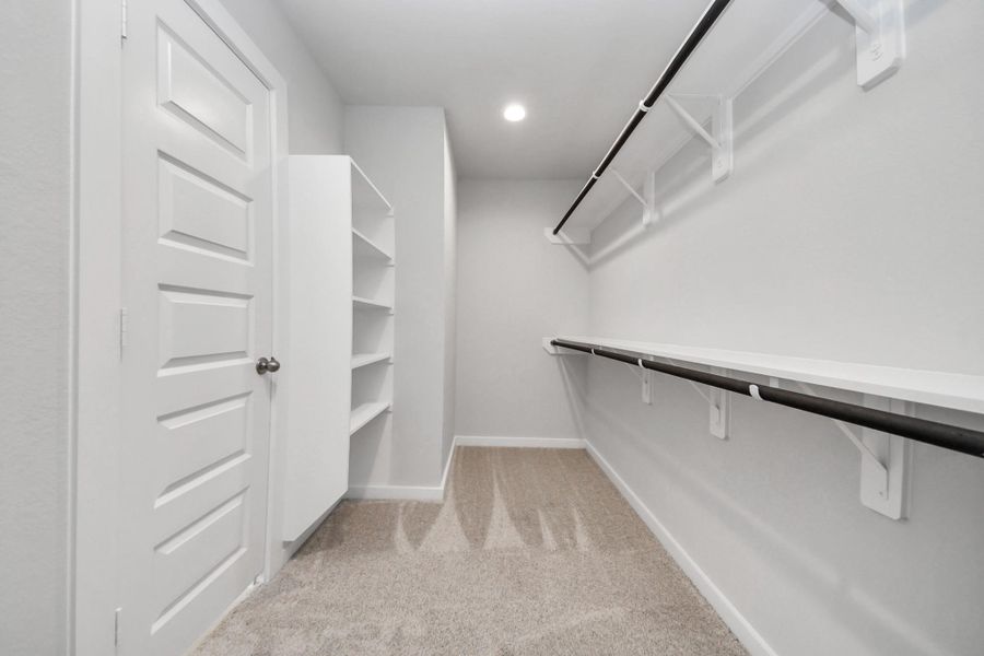 Walk-in closet that epitomizes luxury and practicality. This generously sized space features built-in shelving, offering abundant room for impeccable organization. High ceilings and recessed lighting create a bright and welcoming ambiance.