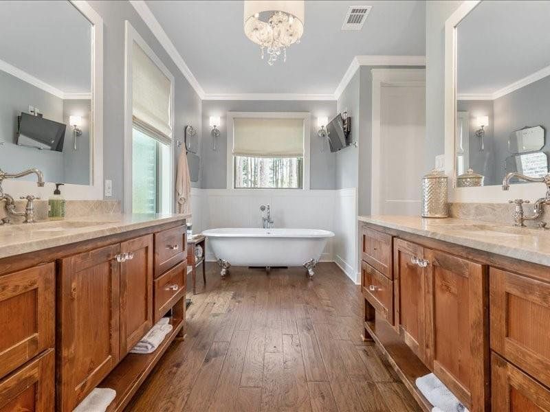 Custom cabinets lead to Cast Iron Bathtub surrounded by bead board.