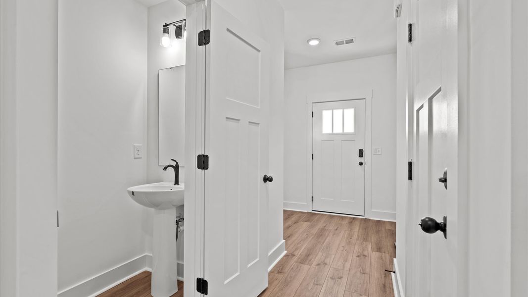 Highly functional foyer with hardwood flooring that flows seamlessly into living spaces