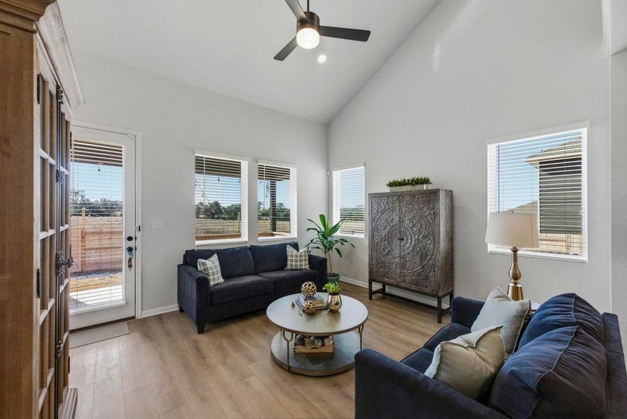 Living area featuring wood finished floors, high vaulted ceiling, recessed lighting, and ceiling fan