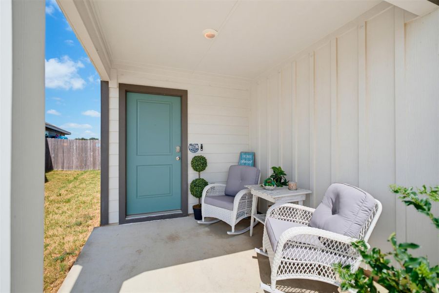 Welcoming front porch features durable concrete flooring and a clean vertical siding finish. Welcoming front porch features durable concrete flooring and a clean vertical siding finish.