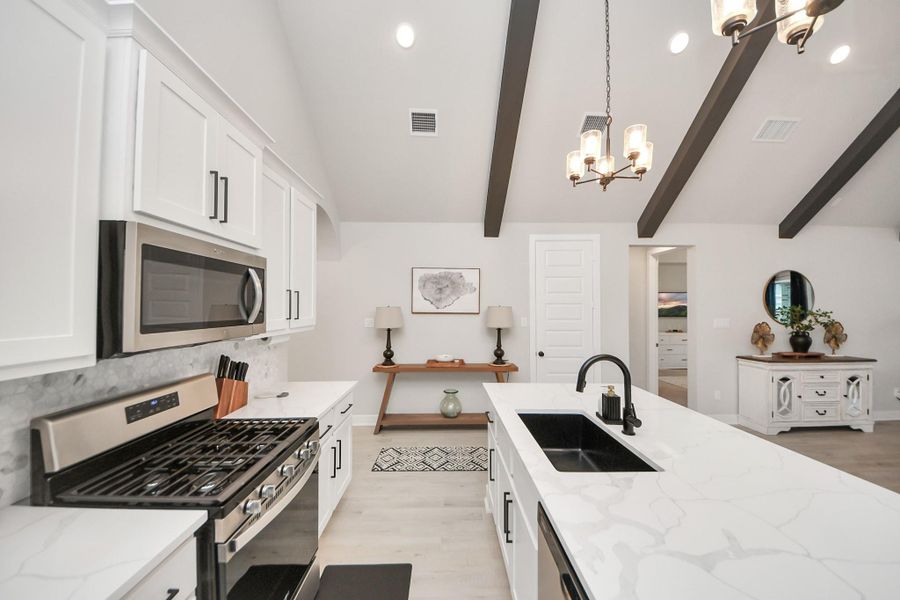 Chef's kitchen with pendant lighting, stainless steel appliances, and ample prep and storage space!
