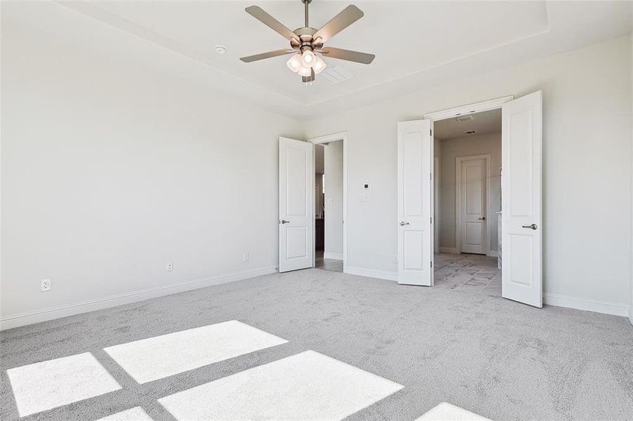 Unfurnished bedroom featuring light colored carpet and ceiling fan