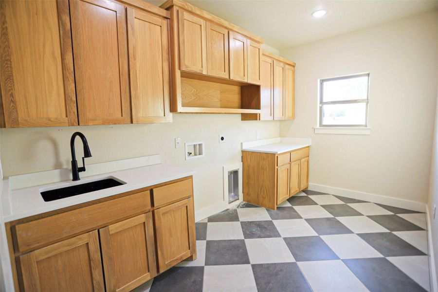 Laundry area featuring dark flooring, hookup for a washing machine, cabinet space, electric dryer hookup, and recessed lighting