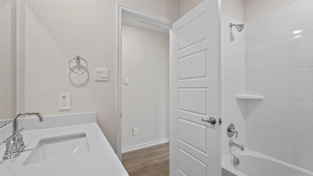 Bathroom featuring a vanity with an integrated sink, polished chrome faucet, and white countertop