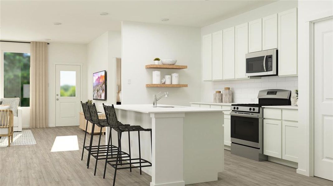 Kitchen with appliances with stainless steel finishes, white cabinetry, an island with sink, sink, and light hardwood / wood-style floors