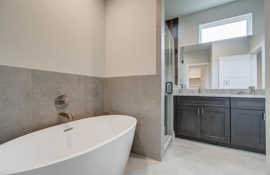 Spacious primary bath with separate shower and tub. (Transitional finish shown).