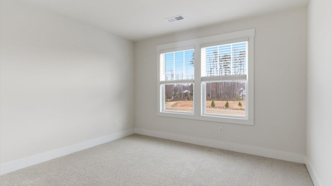 Highly functional bedroom with large windows, carpeted flooring, and tasteful finishes throughout at Pelham Crossing