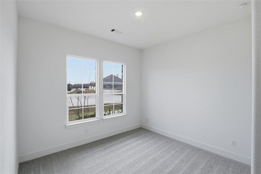 Empty room featuring baseboards and light colored carpet