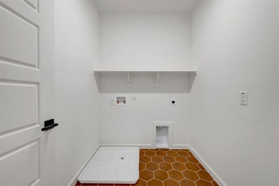 Laundry area featuring hexagon floor tiling, a white built-in shelf, and a utility tray Laundry area featuring hexagon floor tiling, a white built-in shelf, and a utility tray