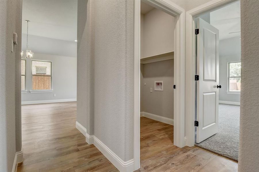 Hallway featuring a notable chandelier and light hardwood / wood-style floors