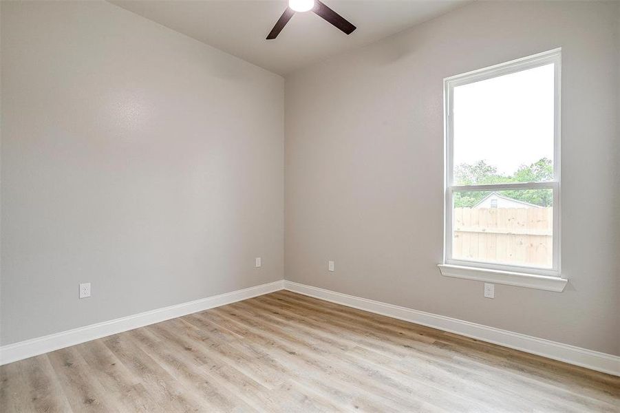 Empty room with light wood-type flooring, baseboards, and ceiling fan Empty room with light wood-type flooring, baseboards, and ceiling fan