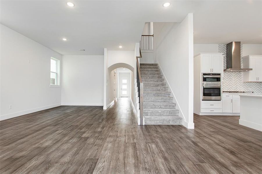 Unfurnished living room with dark wood-type flooring