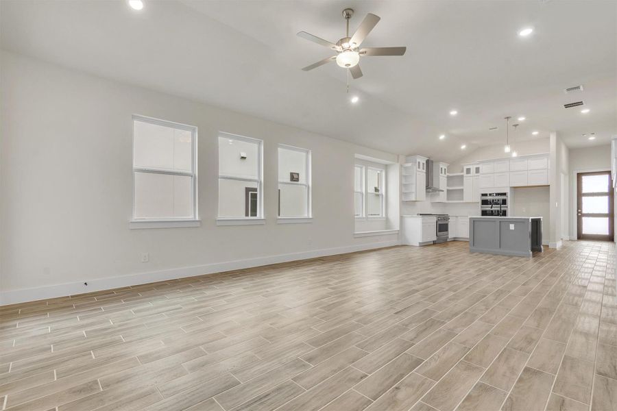 An open concept living area showcasing a sleek kitchen with a central island and abundant natural light.