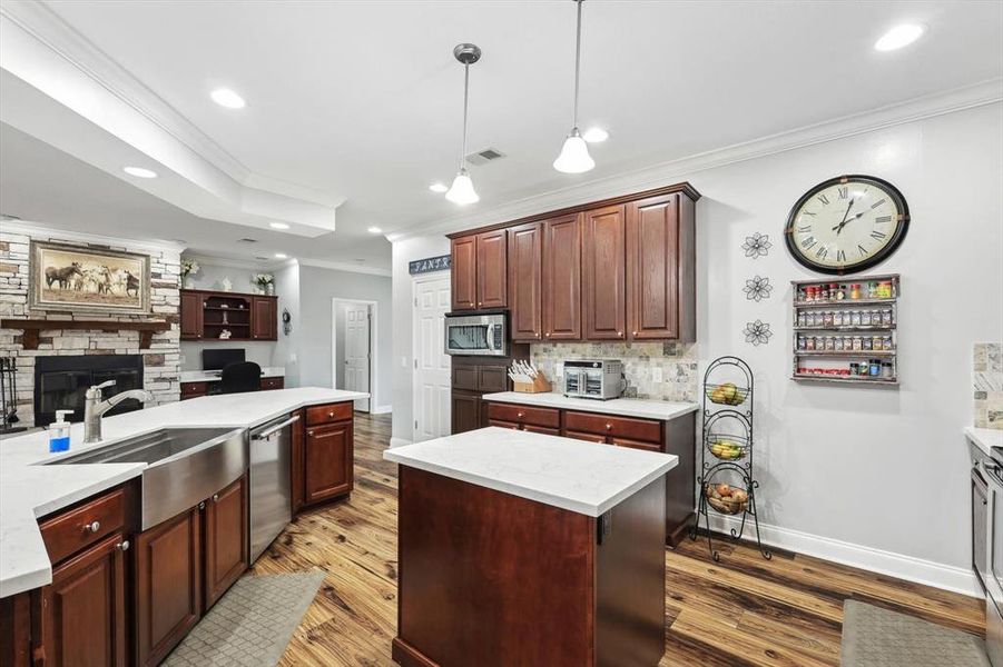 Kitchen with a kitchen island, crown molding, appliances with stainless steel finishes, and sink