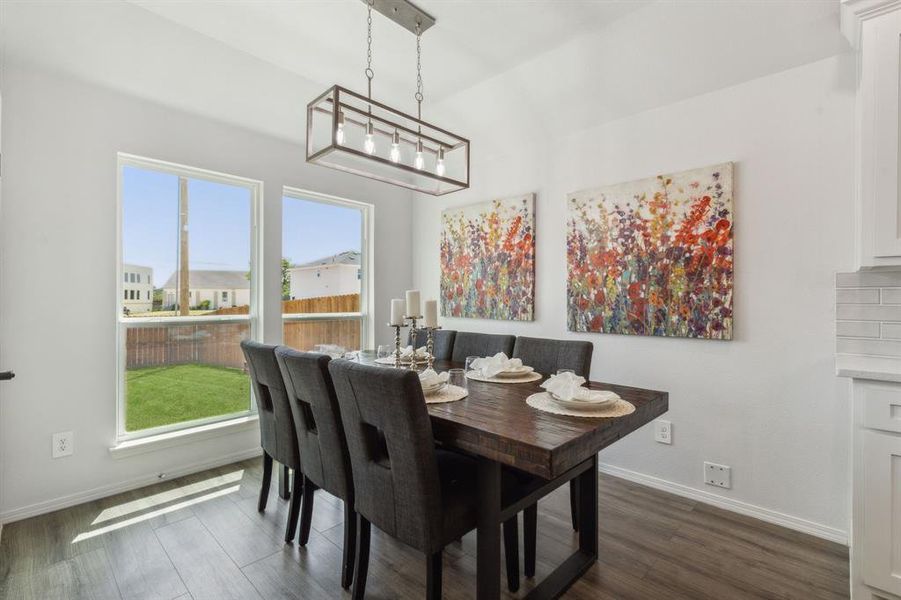 Dining room with a notable chandelier and dark wood-type flooring