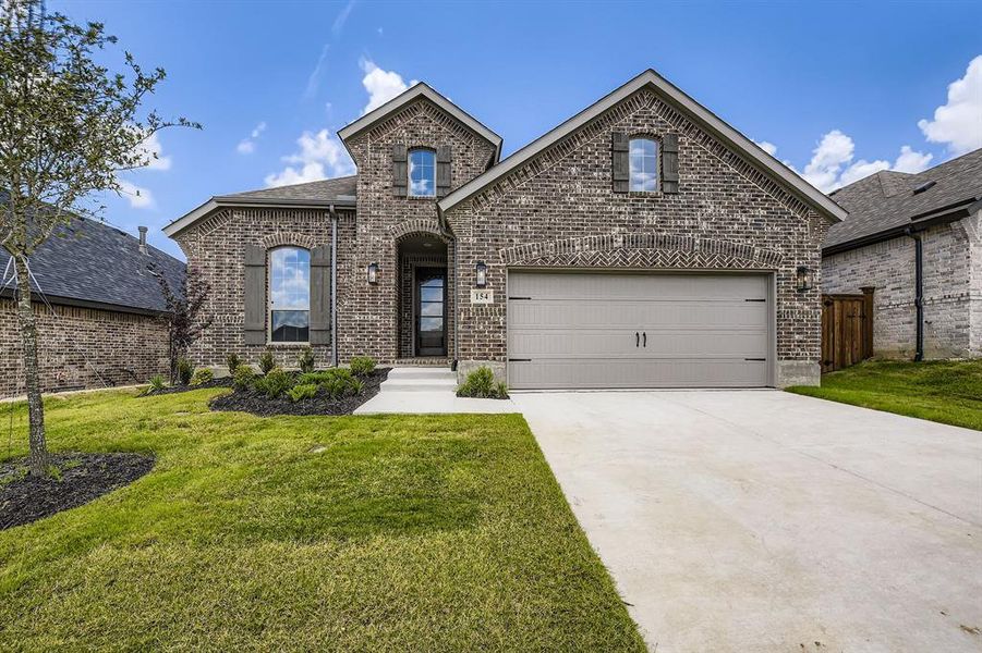 French country style house featuring brick siding and driveway French country style house featuring brick siding and driveway