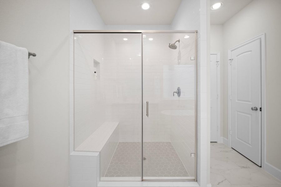 The primary bath's glass-enclosed shower has a built-in bench, niche, and subway tile surround — the linen closet is just to the right of the shower door. The primary bath's glass-enclosed shower has a built-in bench, niche, and subway tile surround — the linen closet is just to the right of the shower door.