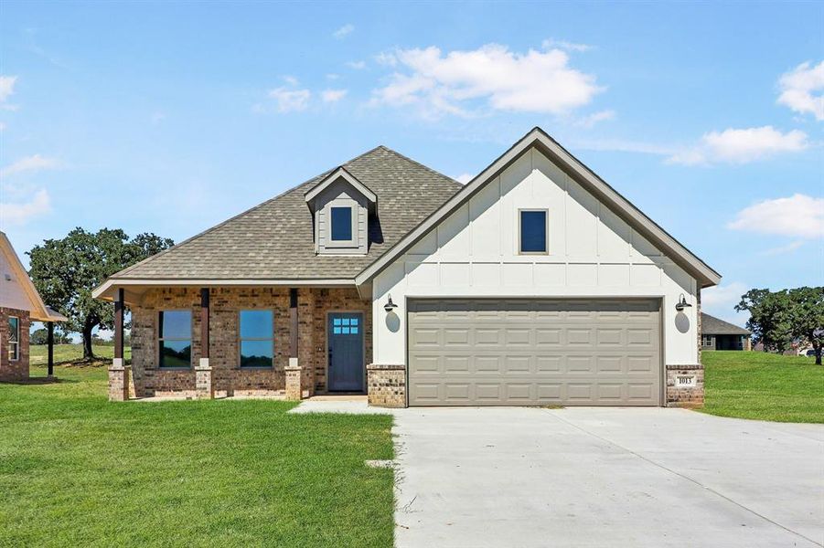 View of front facade with a garage and a front lawn