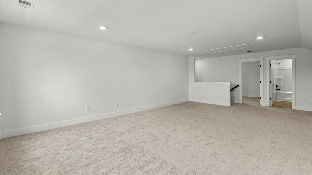 Bonus room with adjoining upper-level bathroom at Chestnut Farms by DRB Homes