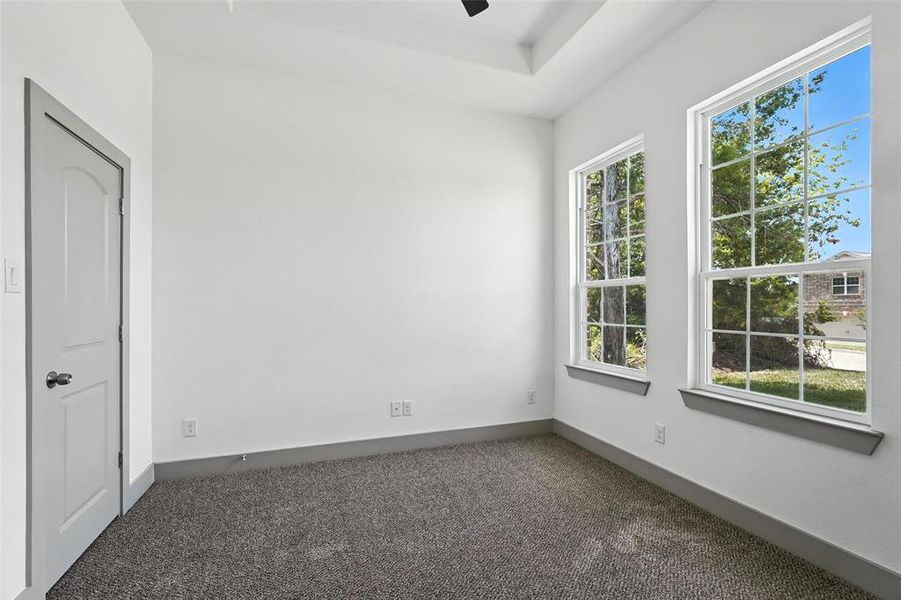 Flex room featuring dark carpet and ceiling fan Flex room featuring dark carpet and ceiling fan