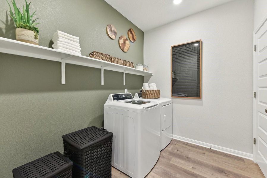 Ample shelving and durable wood-look flooring enhance this highly functional utility space.