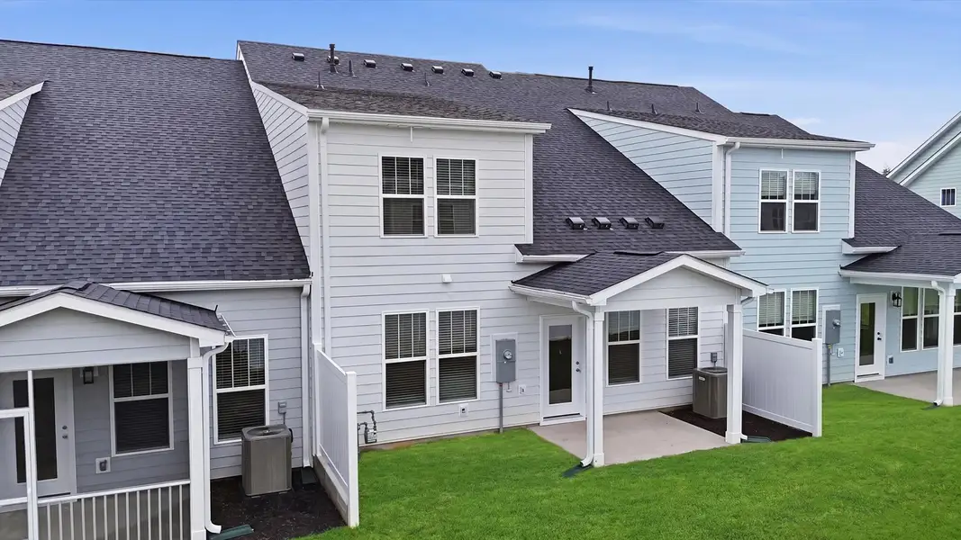 Warm and inviting outdoor living space with a covered rear porch and tasteful finishes at Village at Midway Warm and inviting outdoor living space with a covered rear porch and tasteful finishes at Village at Midway
