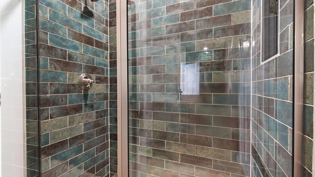 Elegant primary bathroom featuring a spacious walk-in shower and dual vanity in this first-class DRB Homes design