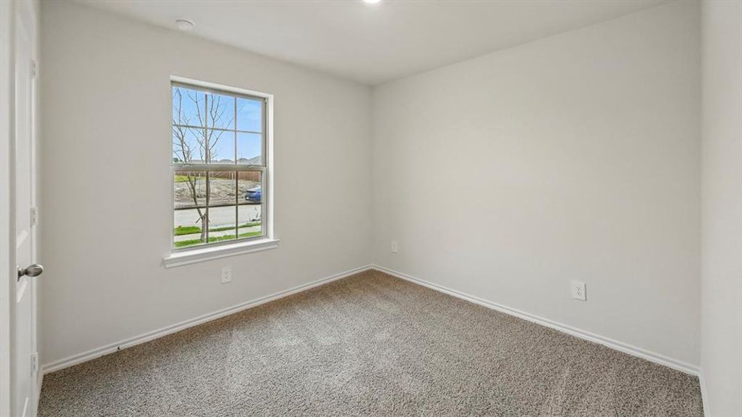Empty room featuring carpet and baseboards