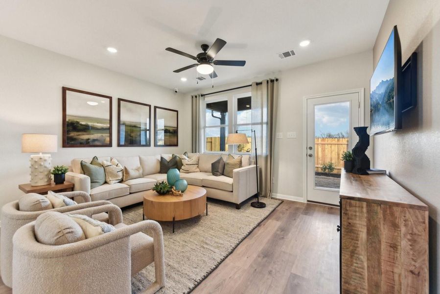 Rich wood-look flooring and recessed lighting define this inviting, open living space.