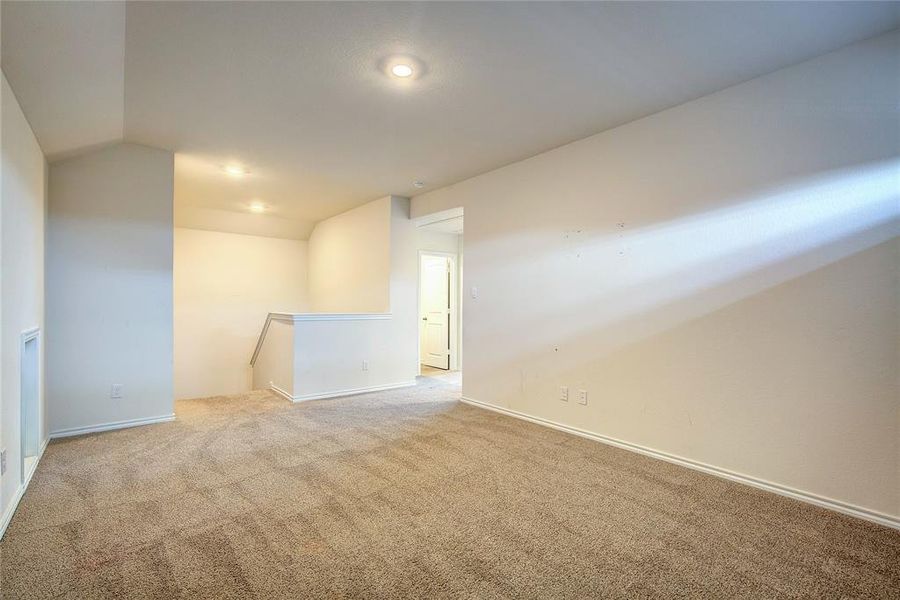 Carpeted spare room featuring lofted ceiling and recessed lighting