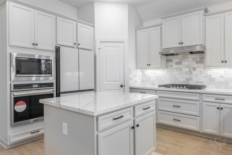 Flooded with natural light, the kitchen features expansive surfaces and upgraded stainless-steel appliances that elevate every culinary moment. Thoughtfully designed cabinetry and a generous island offer exceptional storage and workspace. Flooded with natural light, the kitchen features expansive surfaces and upgraded stainless-steel appliances that elevate every culinary moment. Thoughtfully designed cabinetry and a generous island offer exceptional storage and workspace.