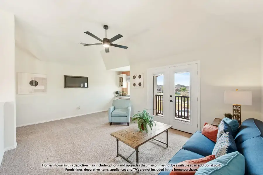 Living room with vaulted ceiling, ceiling fan, carpet, blue sofa, and French doors leading to a balcony.