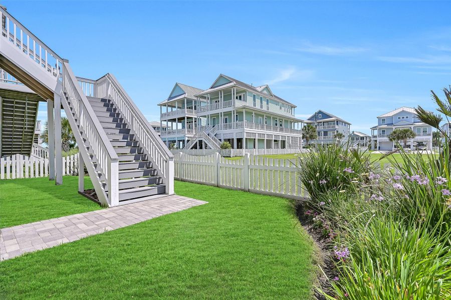 Bring the fur babies! Beautifully maintained back yard and charming coastal walkways create a welcoming approach to the home while showcasing the elevated Beachside Village lifestyle. Surrounded by modern beach homes, this setting feels open, peaceful, and designed for relaxed coastal living.  The gate leads to the greenspace and beach walk over.