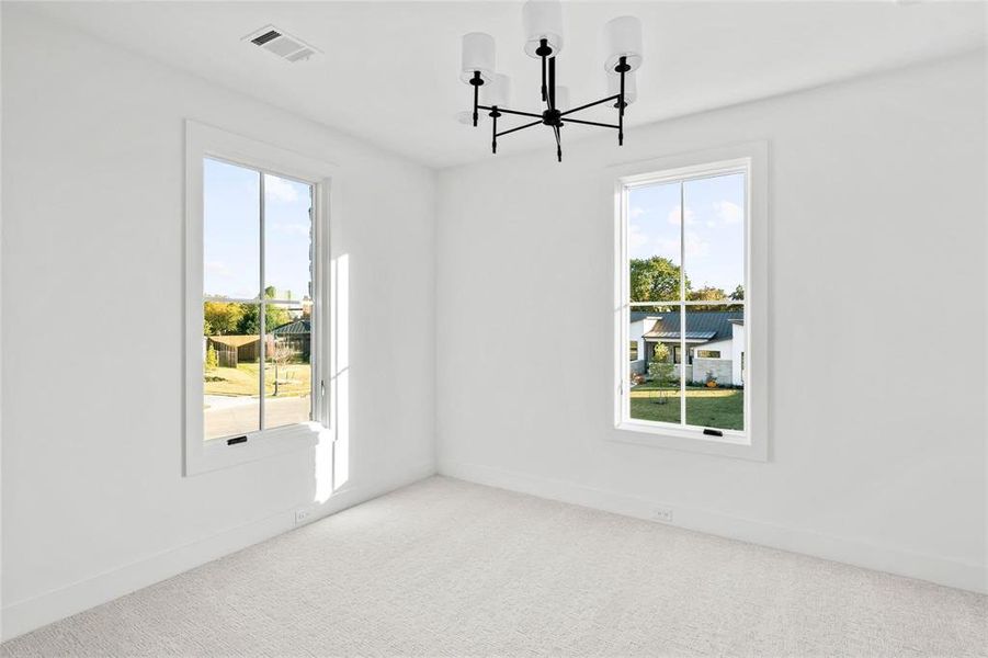 Unfurnished room with a chandelier and carpet flooring Unfurnished room with a chandelier and carpet flooring